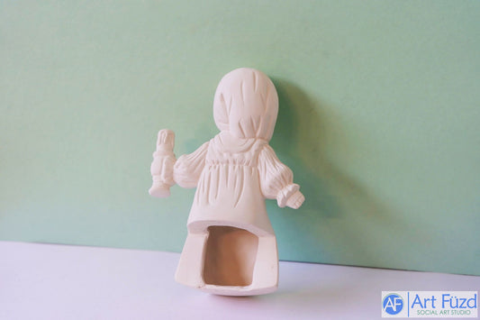 Figura de niña sentada en un estante en pijama y gorro de media sosteniendo una vela en la mano izquierda ~ 5 x 3,5 x 7,5