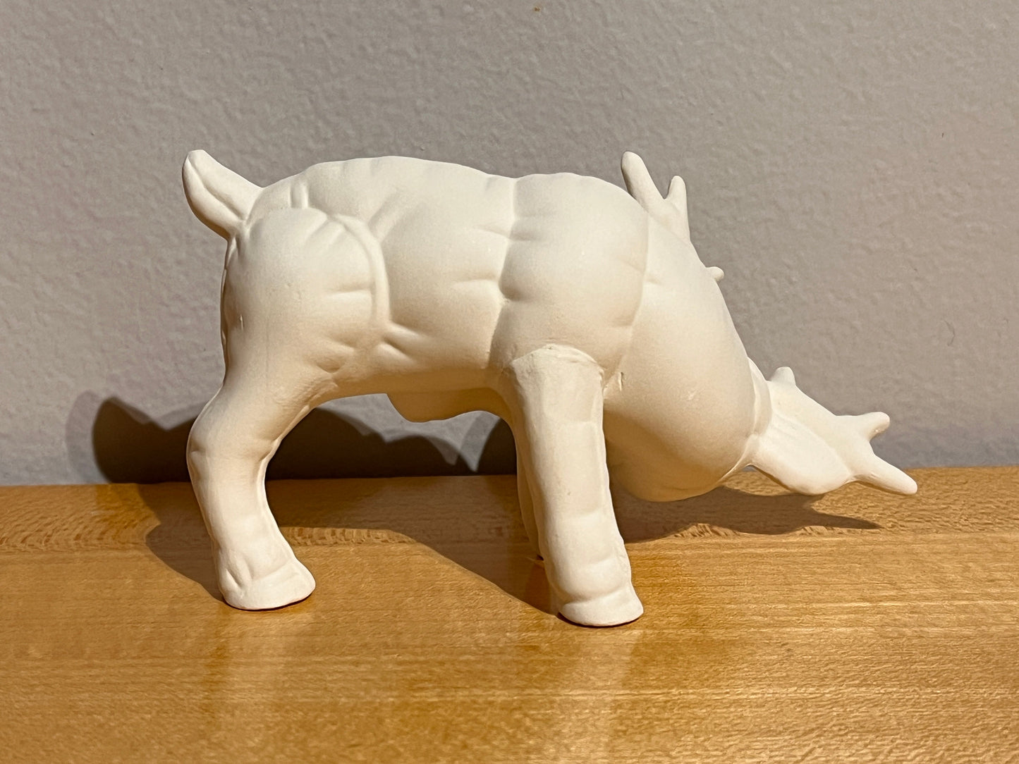 Kleines Softee-Rentier, das sich mit dem Fuß am Ohr kratzt ~ 4,5 x 2,25 x 2,5